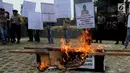 Aktivis Gema Tapteng membakar keranda mayat saat unjukrasa di depan gedung KPK, Jakarta, Rabu (16/5). Mereka mendesak pimpinan KPK segera mengusut sengketa Pilkada Tapanuli Tengah 2011 lalu. (Merdeka.com/Dwi Narwoko)