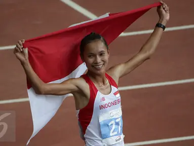 Atlet Indonesia, Rini Budiarti membentangkan bendera Merah Putih usai finish pertama lari halang rintang 3.000 meter SEA Games ke-28 di National Stadium, Singapura, (12/6/2015). Rini mencatat waktu 10 menit 20,40 detik. (Liputan6.com/Helmi Fithriansyah)