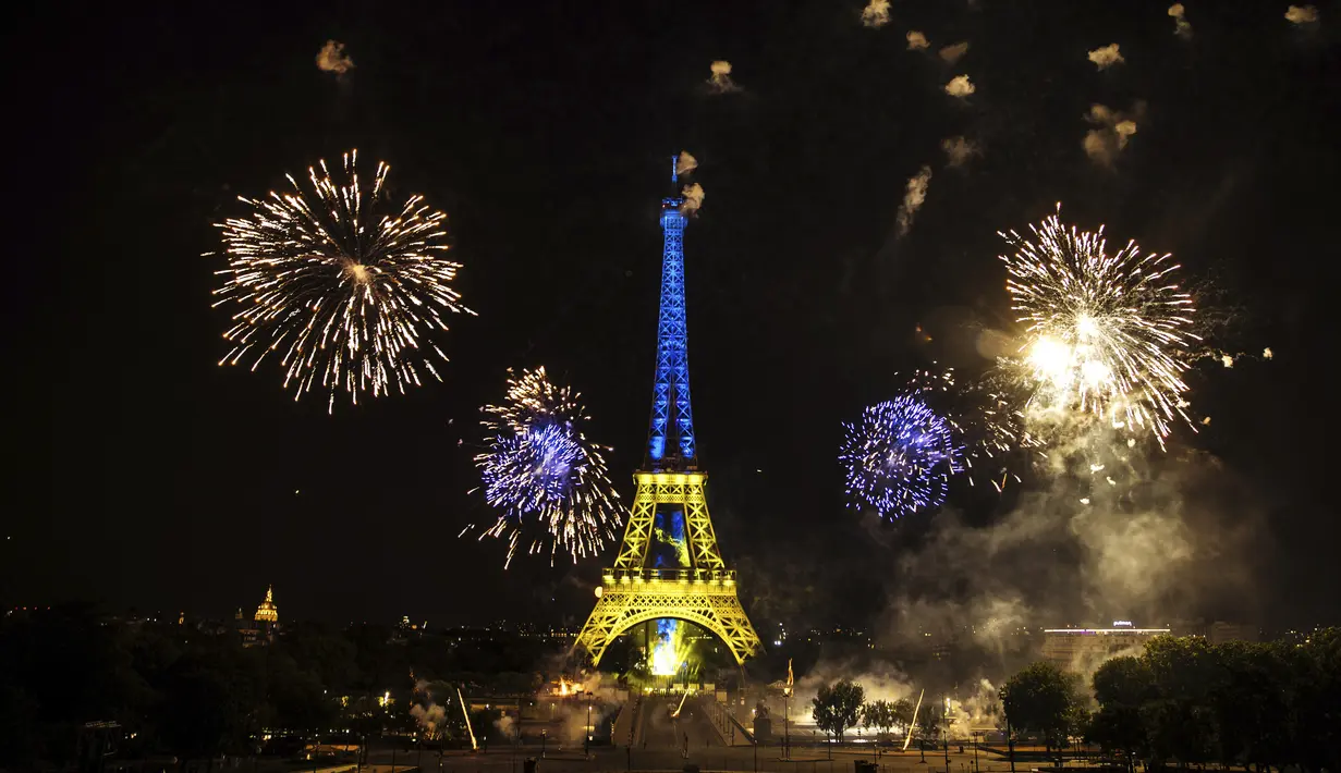 Kembang api menerangi Menara Eiffel selama perayaan Hari Bastille di Paris, Kamis (14/7/2022) malam. Perayaan yang digelar setiap tanggal 14 Juli ini dalam rangka untuk memperingati penyerbuan benteng penjara Bastille pada 14 Juli 1789 silam. (AP Photo/Lewis Joly)