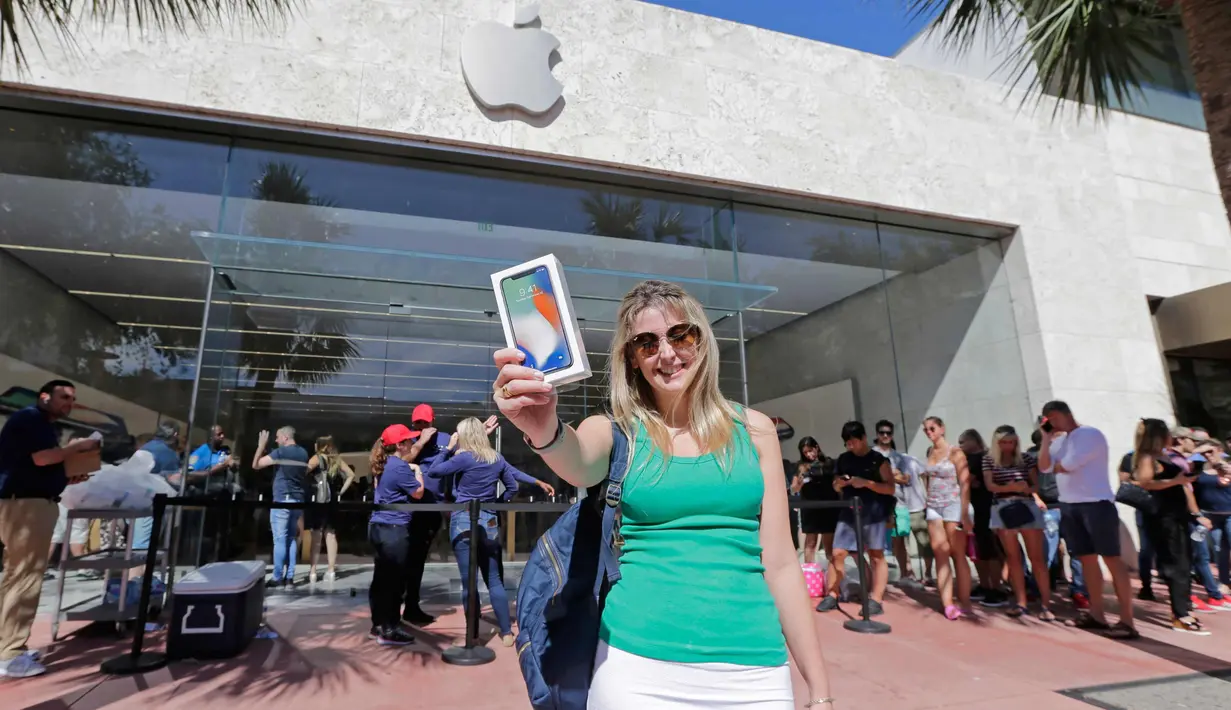 Ana Melchiors, dari Brazil, menunjukkan iPhone X setelah ia membelinya di Miami Beach, Florida (3/11). iPhone X mulai dijual pada hari Jumat (10/11/2017). (AP Photo/Alan Diaz)