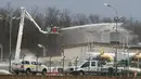 Petugas pemadam kebakaran menyemprotkan air di pusat pipa gas di Baumgarten, Austria, (12/12). Ledakan tersebut belum diketahui secara pasti apa penyebabnya. (AP Photo/Ronald Zak)