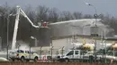 Petugas pemadam kebakaran menyemprotkan air di pusat pipa gas di Baumgarten, Austria, (12/12). Ledakan tersebut belum diketahui secara pasti apa penyebabnya. (AP Photo/Ronald Zak)