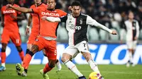 Striker Juventus, Cristiano Ronaldo, berusaha membobol gawang Udinese pada laga Serie A di Stadion Allianz, Turin, Minggu (15/12). Juventus menang 3-1 atas Udinese. (AFP/Isabella Bonotto)