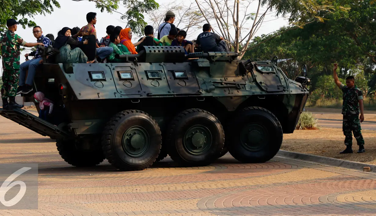 Sejumlah warga menaiki Panser Anoa milik TNI AD di pameran road to campus Alutsista di kawasan Boulevard UI, Jawa Barat, Kamis (27/8/2015). TNI AD menampilkan sejumlah peralatan dan persenjataan di pameran tersebut. (Liputan6.com/Yoppy Renato)