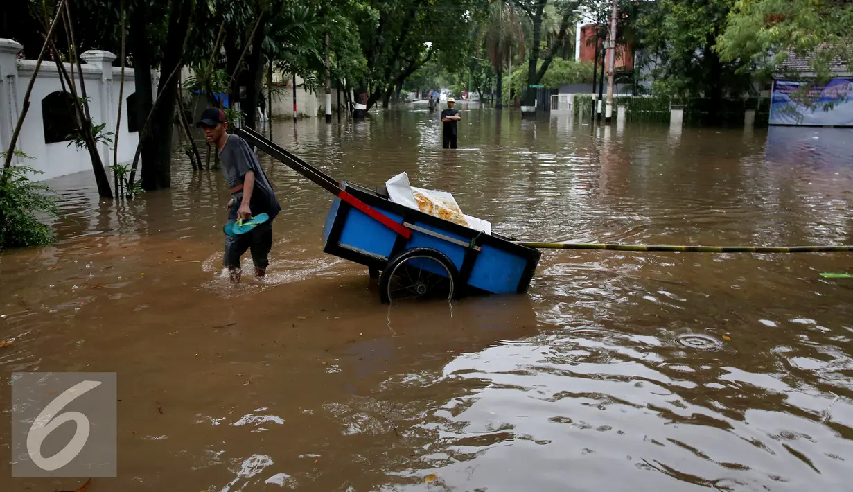 Warga melintasi banjir yang menggenangi Kommplek Perumahan yang Banjir di Hang Lekiu, Kebayoran Baru, Jakarta, Jumat (11/11). Hujan deras disertai angin yang mengguyur wilayah Jakarta, mengakibatkan daerah ini banjir. (Liputan6.com/Johan Tallo)