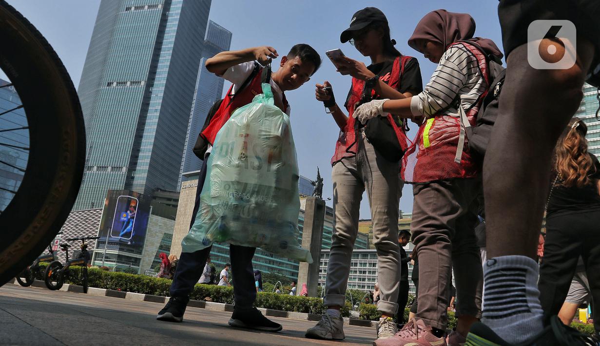 Sejumlah pegiat lingkungan menimbang sampah yang dikumpulkan saat mengikuti Hari Bebas Kendaraan Bermotor (HKBP) atau Car Free Day (CFD) di kawasan Bundaran HI, Jakarta, Minggu (29/10/2023). Kegiatan ini sebagai bentuk kampanye untuk mengajak warga agar peduli terhadap lingkungan dengan cara mengurangi penggunaan plastik. (Liputan6.com/Angga Yuniar)