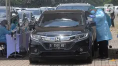 Paramedis mengarahkan pengendara mobil saat vaksinasi COVID-19 secara drive-thru di ICE BSD, Tangerang, Banten, Sabtu (13/3/2021). Sebanyak 5.000 masyarakat umum, lanjut usia (lansia), dan pengemudi ojek online (ojol) divaksin COVID-19 pada hari ini dan besok. (merdeka.com/Arie Basuki)