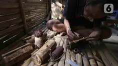 Perajin membuat kerajinan tas dari limbah bambu di Grand Depok City, Depok, Jawa Barat, Kamis (2/6/2022). Komunitas Ciliwung Depok (KCD) memanfaatkan limbah bambu yang berada di Sungai Ciliwung menjadi kerajinan seperti tas, tempat alat tulis, dan cangkir. (Liputan6.com/Herman Zakharia)