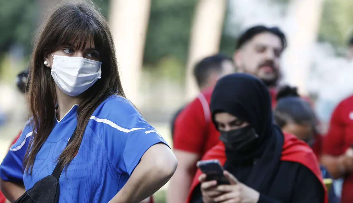 Walaupun harus menonton diluar stadion mereka pun tetap patuh pada protokol kesehatan salah satunya dengan memakai masker yang tak mengurangi kecantikan mereka. (Foto: AP/LaPresse/Cecilia Fabiano)