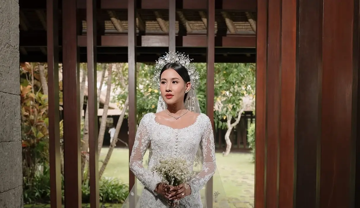 Gaun pengantin Shenina menggabungkan elemen tradisional dan modern dengan sempurna. Detail payet yang cantik menambah kesan elegan pada busana tersebut. Tidak hanya itu, Shenina juga mengenakan mahkota berwarna silver yang membuatnya terlihat seperti putri raja. (Liputan6.com/IG/@sheninacinnamon)