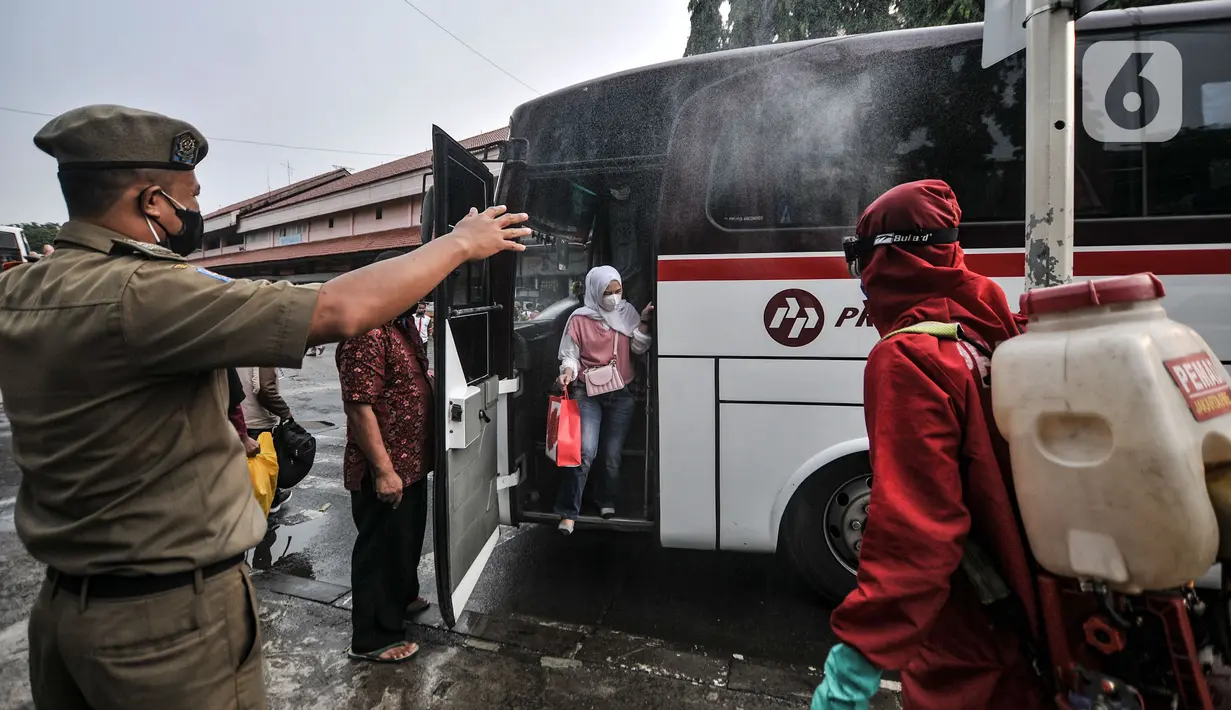 Petugas pemadam kebakaran menyemprotkan disinfektan kepada penumpang bus AKAP di Terminal Kampung Rambutan, Jakarta, Minggu (23/5/2021). Penyemprotan rutin dilakukan kepada bus AKAP dan penumpang selama arus mudik Lebaran sebagai langkah mencegah penyebaran Covid-19. (merdeka.com/Iqbal S Nugroho)