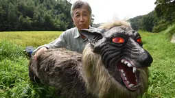 Chikao Umezawa, Ketua Asosiasi Koperasi Pertanian JA Kisarazu-shi, menunjukkan robot Super Monster Wolf di Kisarazu, prefektur Chiba, Jepang, 25 Agustus 2017. Robot serigala ini berhasil dikembangkan oleh Hokkaido Ohta Seiki. (Toru YAMANAKA/AFP)