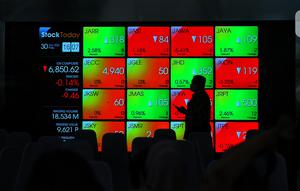 Karyawan melintasi layar yang menampilkan Indeks Harga Saham Gabungan (IHSG) saat acara Penutupan Perdagangan Bursa Efek Indonesia Tahun 2022 di Jakarta, Jumat (30/12/2022). PT Bursa Efek Indonesia (BEI) mencatat ada 59 perusahaan yang melakukan Initial Public Offering (IPO) atau pencatatan saham sepanjang 2022. Pada penutupan perdagangan akhir tahun, Indeks Harga Saham Gabungan (IHSG) ditutup lesu 0,14% atau 9,46 poin menjadi 6.850,62. (Liputan6.com/Angga Yuniar)
