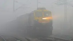Sebuah kereta melaju dalam kabut tebal di Jalandhar (25/12). India ditetapkan darurat polusi udara. Kualitas udara yang semakin buruk dan kabut beracun menyelimuti seluruh kota. (AFP Photo/Shammi Mehra)
