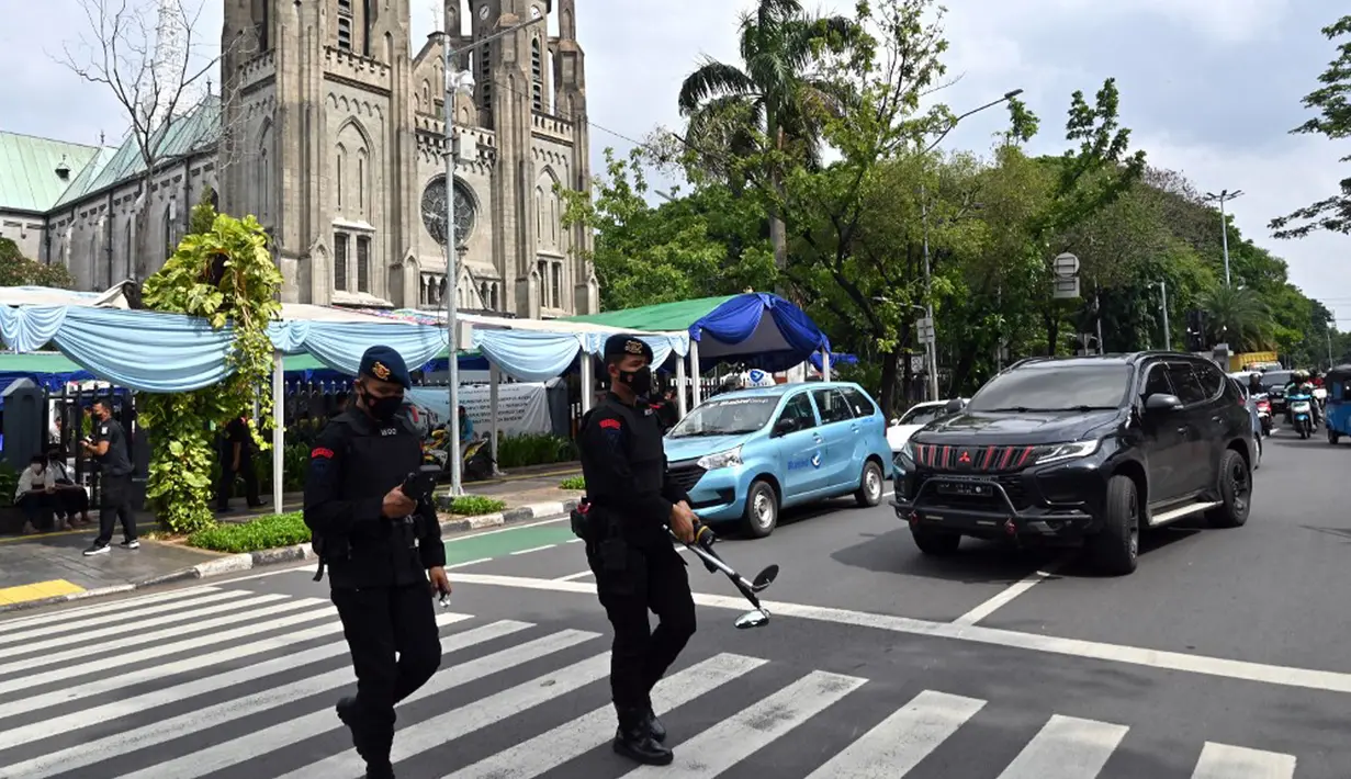 Polisi antiteror berjalan di luar Gereja Katedral usai melakukan pemeriksaan keamanan jelang malam Natal di Jakarta, Sabtu (24/12/2022). Pengamanan dilakukan di sejumlah gereja di berbagai wilayah guna menciptakan rasa aman dan khidmat bagi warga yang akan melangsungkan ibadah malam Natal. (ADEK BERRY/AFP)