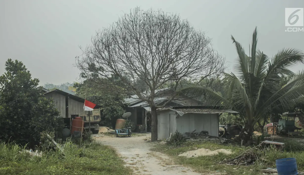 Bendera setengah tiang berkibar di sebuah rumah di Kabupaten Siak, Riau, Kamis (12/9/2019). Pengibaran bendera setengah tiang itu dilakukan sebagai Hari Berkabung Nasional selama tiga hari ke depan untuk menghormati almarhum Presiden ke-3 Indonesia BJ Habibie. (Liputan6.com/Faizal Fanani)