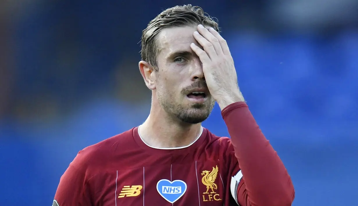Kapten Liverpool, Jordan Henderson, menutup sebelah mukanya saat melawan Everton pada laga Liga Inggris di Stadion Goodison Park, Minggu (21/6/2020). (Peter Powell/Pool via AP)