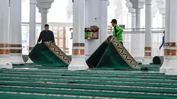 Seperti diketahui, Pemerintah melalui Sidang Isbat yang dilaksanakan Kementerian Agama telah menetapkan awal puasa 1 Ramadan 1447 Hijriah jatuh pada Kamis 19 Februari 2026. Tampak dalam foto, para pekerja menyiapkan karpet untuk salat tarawih pertama pada bulan suci Ramadan 1447 Hijriah di Masjid Agung Baiturrahman, Banda Aceh, Rabu 18 Februari 2026. (CHAIDEER MAHYUDDIN/AFP)