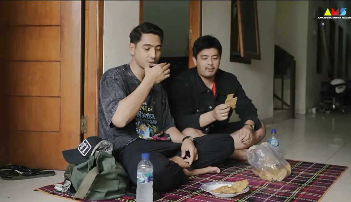 Mengenang masa-masa tinggal di kos, Arya Saloka duduk santai sambil ngopi dan makan gorengan di depan kamarnya. [Youtube/Rumah Kelana Pictures]