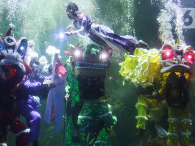 Sejumlah penampil menunjukkan atraksi barongsai di dalam akuarium Sea World Ancol, Jakarta, Rabu (18/1/2023). Pertunjukan barongsai bawah air tersebut merupakan rangkaian Ancol Lunar Fest 2023 dalam rangka menyambut Tahun Baru Imlek 2574 Kongzili. (Liputan6.com/Herman Zakharia)