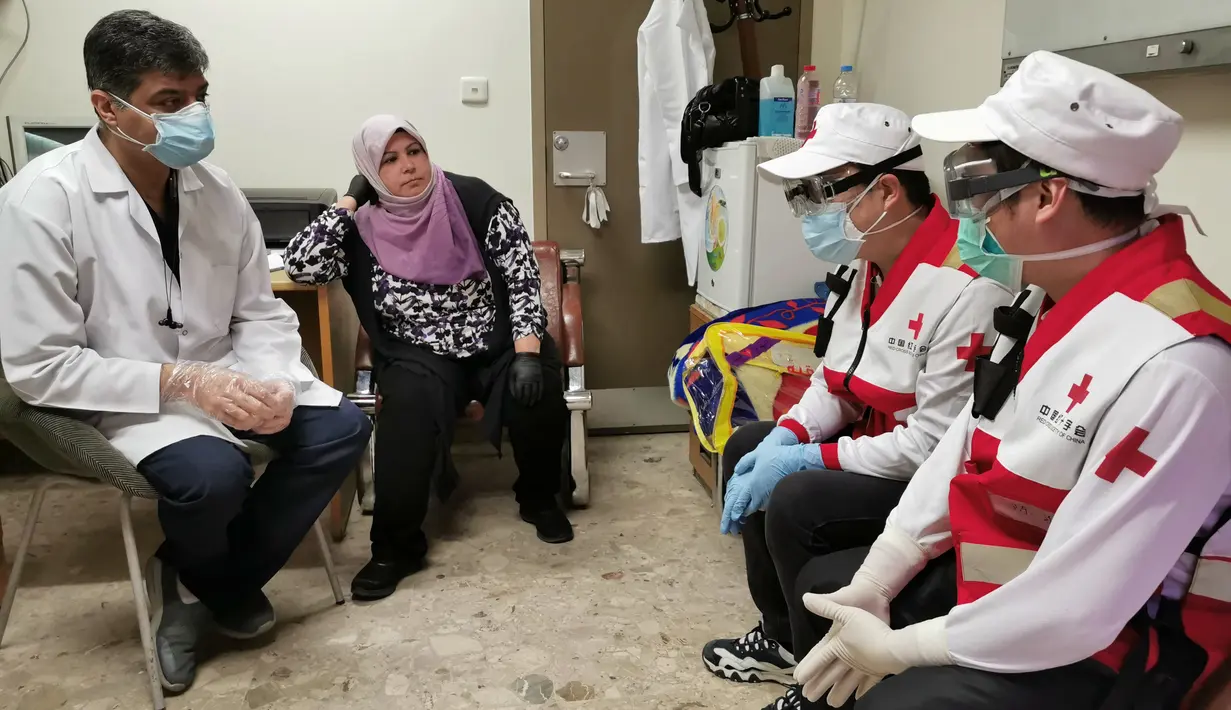 Anggota tim pakar medis China, Chen Huai (kanan) dan Ai Hexu (kedua kanan) berbicara dengan dua ahli radiologi lokal di Baghdad, Irak, Senin (30/3/2020). Sejak 7 Maret lalu, tujuh pakar medis China bekerja sama dengan tenaga ahli lokal di Irak untuk memerangi epidemi virus corona COVID-19. (Xinhua)
