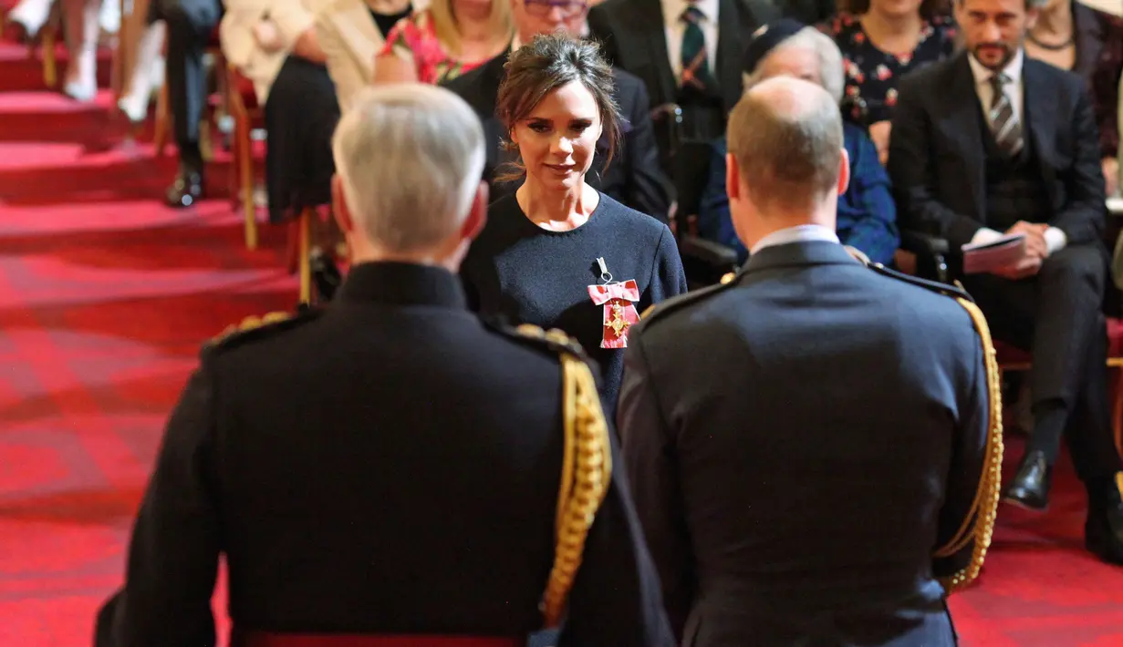 Desainer Victoria Beckham saat menerima gelar Order of the British Empire (OBE) dari Pangeran William di Istana Buckingham, London (19/4). Ibu 4 anak ini mendapatkan gelar kehormatan di bidang fashion selama 17 tahun.  (Yui Mok / PA via AP)