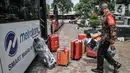Petugas saat membawa barang-barang milik atlet kontingen DKI Jakarta saat tiba di Hotel Grand Cempaka Business, Jakarta, Kamis (14/10/2021). Para atlet dikarantina sebagai upaya pencegahan penyebaran virus Covid-19. (merdeka.com/Iqbal S. Nugroho)