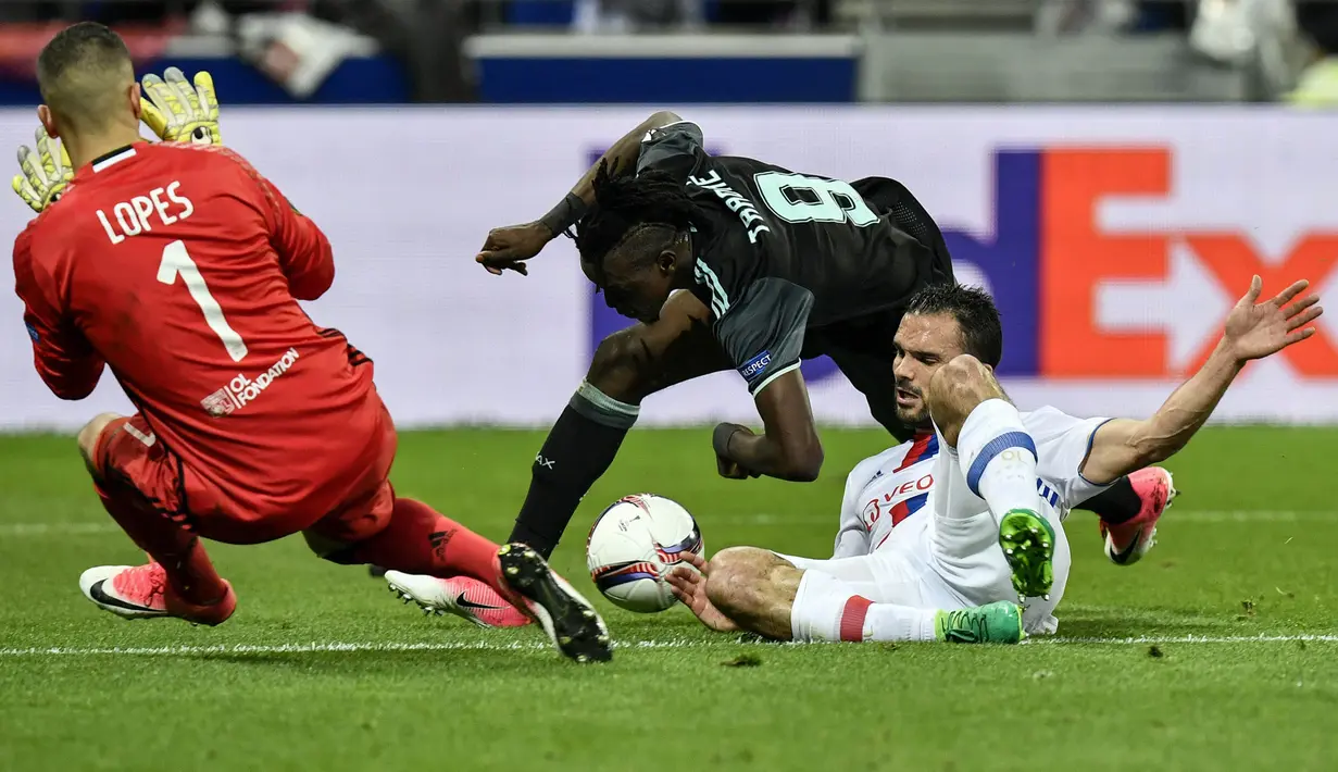 Striker Ajax Amsterdam, Bertrand Traore, berebut bola dengan bek Olympique Lyon, Jeremy Morel, pada laga semifinal Liga Europa di Stadion Parc Olympique Lyonnais, Kamis (12/05/2017). Lyon menang dengan skor 3-1. (AFP/Jeff Pachoud)