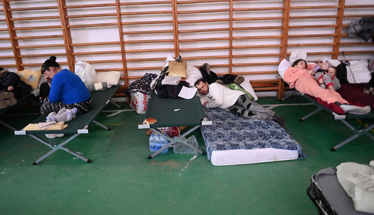 Pengungsi Ukraina terlihat di pusat pengungsian sementara di sekolah dasar setempat di Tiszabecs, Hongaria timur, 28 Februari 2022. Warga Hungaria bergegas ke perbatasan Ukraina untuk membantu pengungsi yang melarikan diri dari invasi Rusia. (Attila KISBENEDEK/AFP)