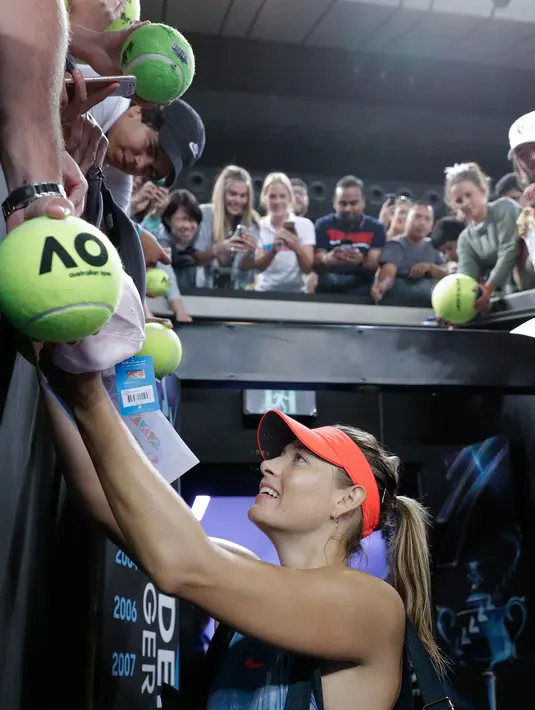 Petenis Rusia, Maria Sharapova memberikan tanda tangan kepada penggemarnya setelah menang atas petenis Swedia Rebecca Peterson pada pertandingan putaran kedua turnamen Australia Terbuka di Melbourne, Kamis (17/1). (AP Photo/Aaron Favila)
