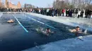 Suasana kompetisi renang musim dingin tahunan dengan air es beku di Trakai, Lituania (24/2). Para peserta tetap antusias mengikuti lomba walaupun dengan suhu di luar hingga minus 12 derajat Celcius. (AFP Photo/Petras Malukas)