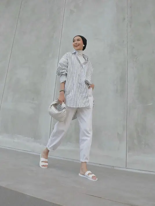 Butuh inspirasi office look dengan celana jeans putih, coba tiru OOTD fashion blogger Vira Tandia berikut ini. Padukan oversized shirt dengan turtleneck top dan celana jeans warna putih. (Instagram/viratandia).