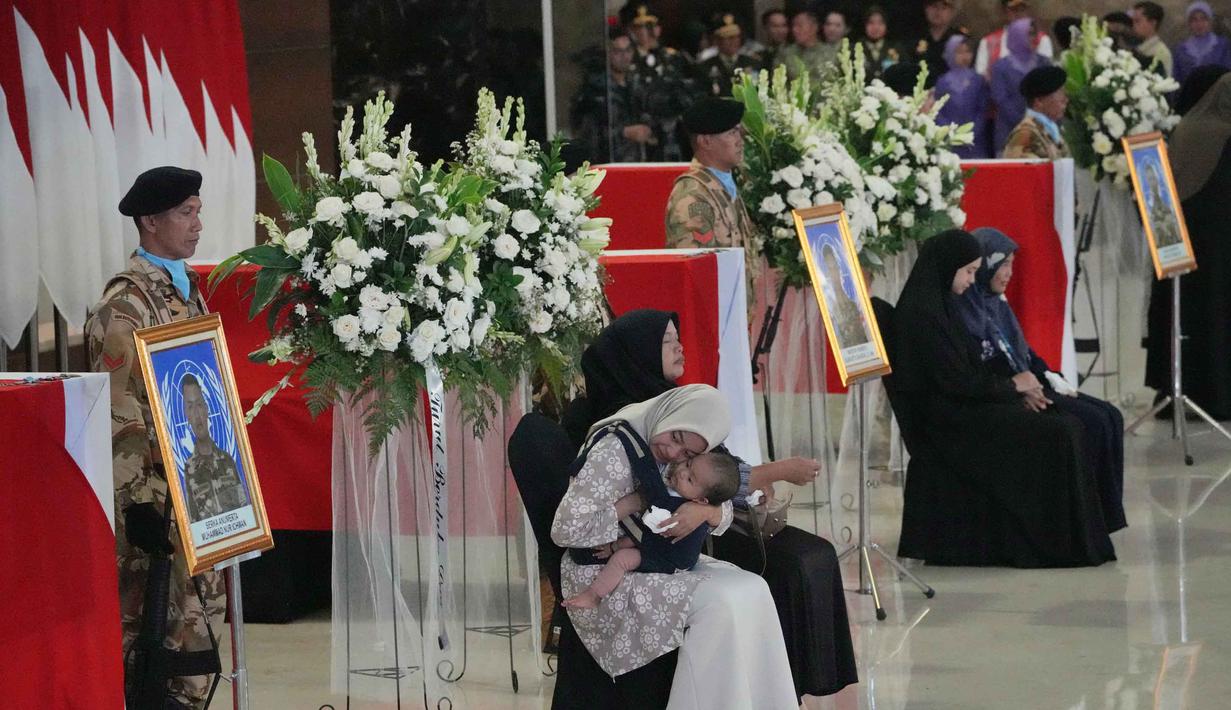 Dalam prosesi tersebut, tiga jenazah yang ditempatkan dalam tiga peti berbendera Merah Putih serta diletakkan di area utama selama berlangsungnya persemayaman dan upacara militer. Tampak dalam foto, kerabat personel pasukan penjaga perdamaian yang tergabung dalam United Nations Interim Force in Lebanon (UNIFIL) yang gugur saat bertugas bersama pasukan sementara Perserikatan Bangsa Bangsa (PBB) di Lebanon, menangis saat upacara penghormatan militer di Bandara Internasional Soekarno-Hatta, Tangerang, Banten, Sabtu, 4 April 2026. (AP Photo/Achmad Ibrahim)