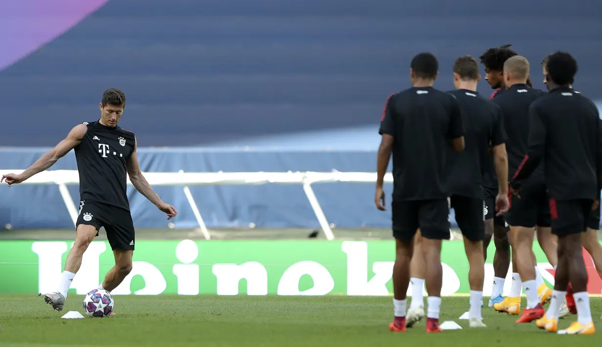 Pemain Bayern Munchen Robert Lewandowski (kiri) menendang bola saat sesi latihan di Stadion Jose Alvalade, Lisbon, Selasa (18/8/2020). Bayern Munchen akan menghadapi Lyon pada pertandingan semifinal Liga Champions. (Miguel A. Lopes/Pool via AP)