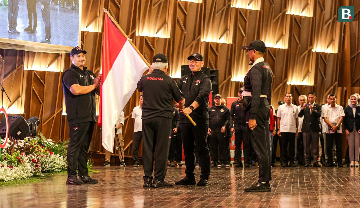 <p>Ketua NOC, Raja Sapta Oktohari (tengah kanan) menyerahkan bendera merah putih kepada Chef de Misson (CdM) Indonesia di Asian Games 2022, Basuki Hadimuljono saat pengukuhan Tim Indonesia untuk Asian Games 2022 Hangzhou di Auditorium Kementerian PUPR, Jakarta, Selasa (19/09/2023). (Bola.com/Bagaskara Lazuardi)</p>
