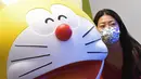 Seorang wanita berfoto dengan patung Doraemon di pameran "Doraemon's Time-Travelling Adventures in Singapore" yang digelar di Museum Nasional Singapura pada 3 November 2020. Pameran ini akan berlangsung hingga 27 Desember 2020. (Xinhua/Then Chih Wey)