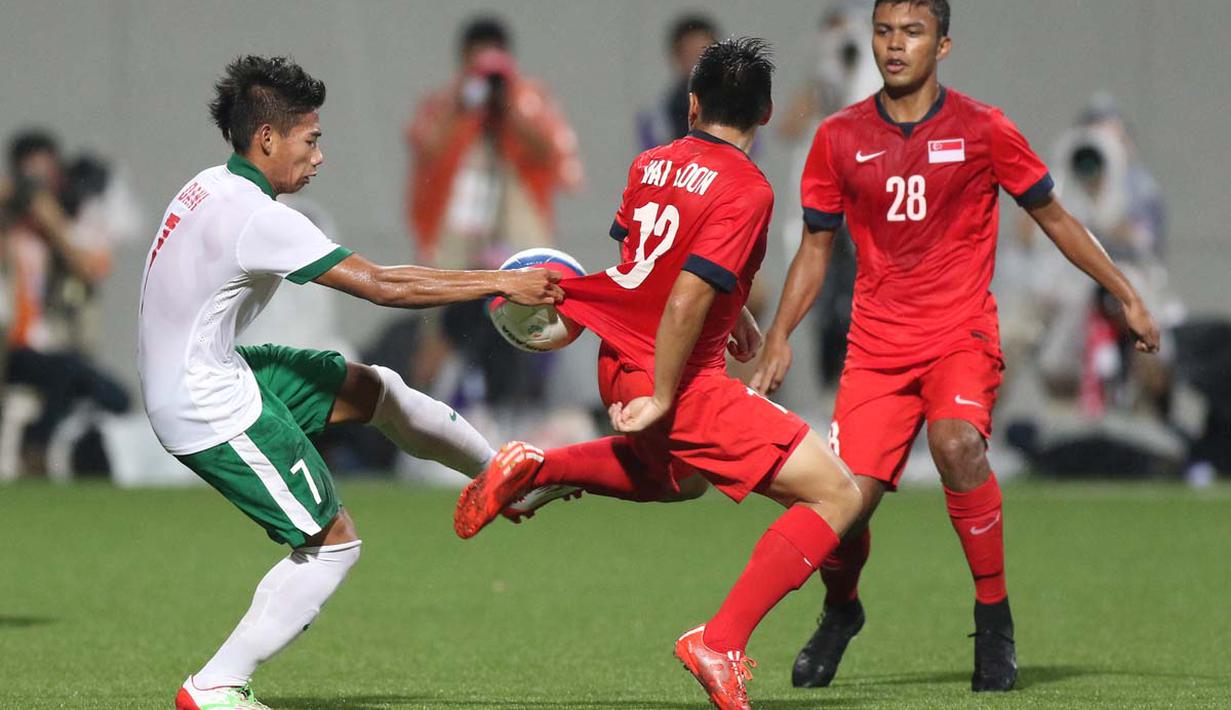 Pemain Indonesia U-23, Ahmad nufiandani (kiri), berebut bola dengan pemain Singapura U-23. (Bola.com/Arief Bagus)