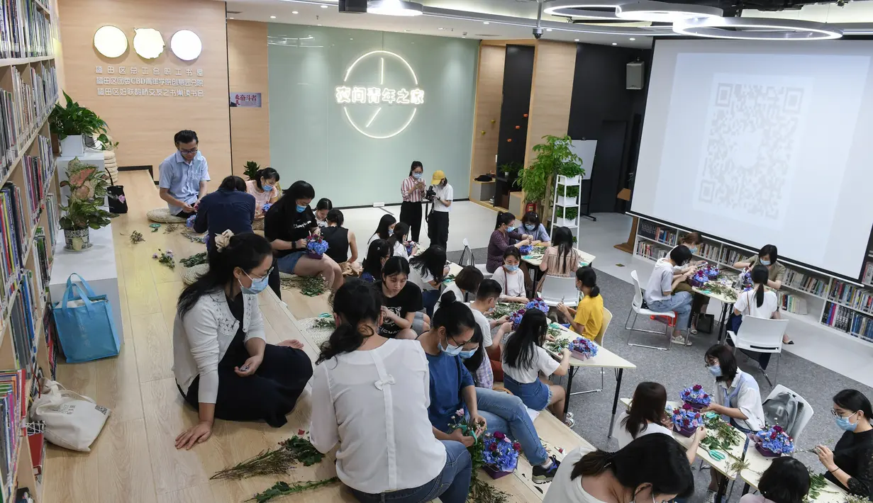 Orang-orang menghadiri kelas merangkai bunga di "Youth Channel" di Shenzhen, China (2/9/2020). Youth Channel adalah pusat komunitas yang menyediakan kuliah dan kelas budaya, seperti kursus ukulele dan keterampilan merangkai bunga bagi kaum muda sepulang bekerja. (Xinhua/Mao Siqian)
