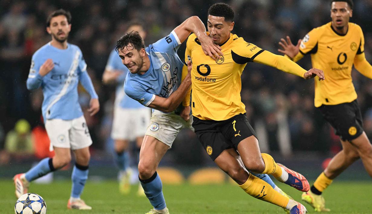 Pada menit ke-72, Borussia Dortmund berhasil memperpendek ketinggalan gol lewat aksi Waldemar Anton. Tampak dalam foto, penyerang Manchester City asal Mesir, Omar Marmoush (kiri) berbenturan dengan gelandang Dortmund asal Inggris, Jobe Bellingham dalam pertandingan lanjutan fase liga Liga Champions 2025/2026 antara Manchester City dan Borussia Dortmund di Stadion Etihad, Manchester, Inggris barat laut, pada 5 November 2025 waktu setempat atau Kamis (6/11) dini hari WIB. (Oli SCARFF/AFP)