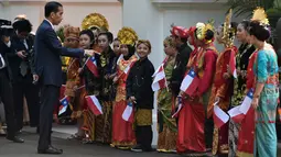 Presiden Jokowi menyapa anak-anak berpakaian tradisional Nusantara saat menunggu kedatangan Presiden Republik Chile, Michelle Bachelet di Istana Kepresidenan, Jakarta, Jumat (12/5). Kedatangan Bachelet disambut dengan parade kenegaraan. (Bay ISMOYO/AFP)