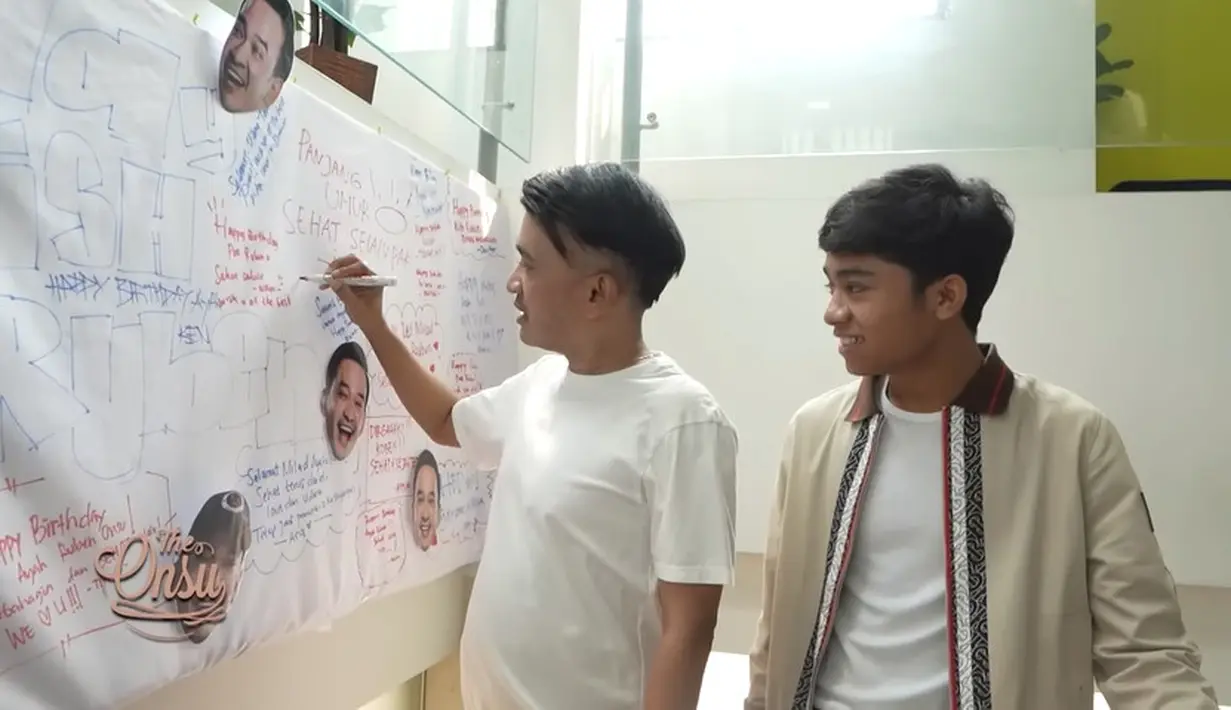 Tidak hanya mendapatkan surprise di rumah, di kantor MOP juga mendapatkan kejutan yang tak kalah meriah. Baru tiba, Ruben langsung digandeng Onyo untuk melihat ucapan dan doa dari anak, istri, keluarga hingga karyawannya. [Youtube/The Onsu Family]