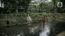 Anak-anak bermain saat mencari belut di anak kali menteng, Jakarta, Selasa (8/6/2021). Ruang bermain anak-anak di Jakarta kian terbatas. Terbatas lahan bermain membuat anak-anak Jakarta bermain ditempat yang tak semestinya demi mencari kesenangan. (Liputan6.com/Faizal Fanani)