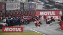 Para pembalap menuju pit untuk mengganti ban motornya saat hujan mengguyur pada lap pertama MotoGP Jepang 2023 di Sirkuit Motegi, Minggu (1/10/2023) siang WIB. (AFP/Toshifumi Kitamura)
