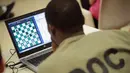 Seorang narapidana Cook County serius memperhatikan laptop saat bertanding catur melawan Penjara Viana dari Brasil di Chicago, Illinois (17/5). Ini ketiga kalinya kompetisi catur internasional untuk para narapidana digelar. (Scott Olson/Getty Images/AFP)