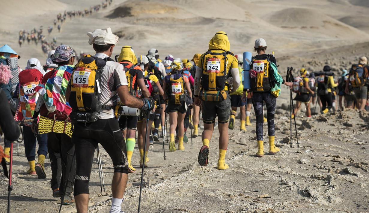 Para peserta melanjutkan perjalanan saat mengikuti lomba marathon sejauh 250 kilometer di Gurun Ica, Kamis (30/11/2017). Marathon yang terbagi dalam enam tahapan ini diprediksi akan berakhir pada 4 Desember. (AFP/Jean-Philippe Ksiazek)