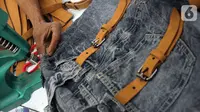 Perajin menyelesaikan pembuatan tas dari bahan celana jeans bekas di Legok, Tangerang, Banten, Senin (11/11/2019). Tas berbahan jeans itu dipasarkan ke kawasan Bandung serta pasar daring. (merdeka.com/Arie Basuki)