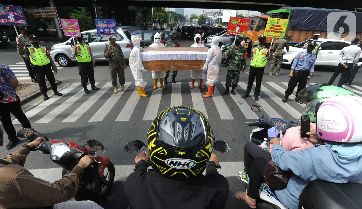 Petugas Gabungan membawa peti mati di hadapan pengendara bermotor di perempatan Fatmawati, Jakarta Selatan, Kamis (3/9/2020). Kegiatan berkeliling membawa peti jenasah tersebut dilakukan oleh petugas gabungan dari wilayah Kecamatan Cilandak. (merdeka.com/Arie Basuki)