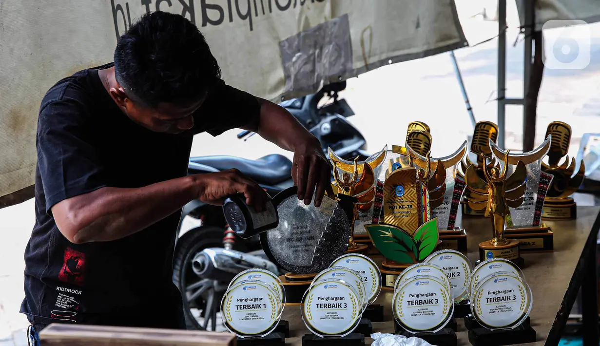 Pekerja menyelesaikan pembuatan plakat maupun piala untuk pemenang lomba di kawasan Ciledug, Kota Tangerang, Banten, Rabu (7/8/2024). (Liputan6.com/Angga Yuniar)