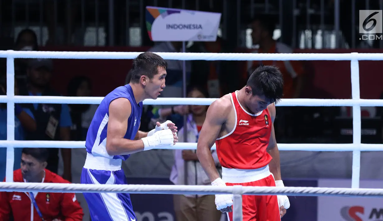 Petinju putra Indonesia, Sunan Agung Amoragam (kaus merah) usai melawan Mirazizbek Mirzakhalilov (Uzbekistan) pada semifinal bantam 56kg putra Asian Games 2018 di JIEXPO Kemayoran, Jumat (31/8). Amoragam kalah 0-5. (Liputan6.com/Helmi Fithriansyah)