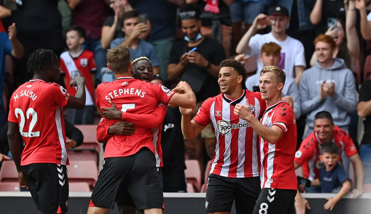 Para pemain Southampton melakukan selebrasi usai tendangan Che Adams (kedua dari kanan) dibelokkan pemain Manchester United Fred sehingga menghasilkan gol bunuh diri pada pertandingan Liga Inggris di Stadion St Mary, Southampton, Inggris, 22 Agustus 2021. Pertandingan berakhir 1-1. (Glyn KIRK/AFP)